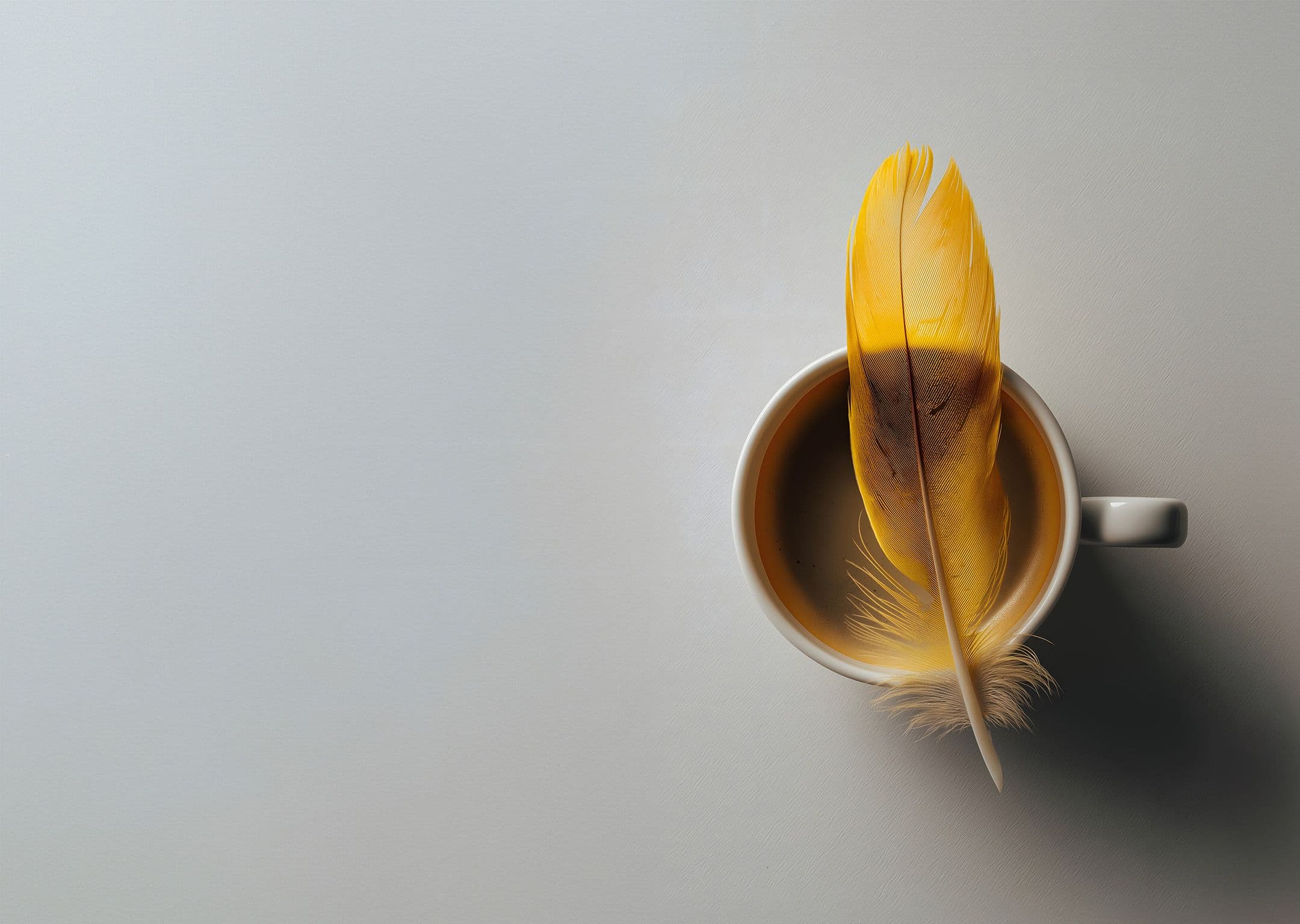 A coffee cup with a yellow feather resting on the brim