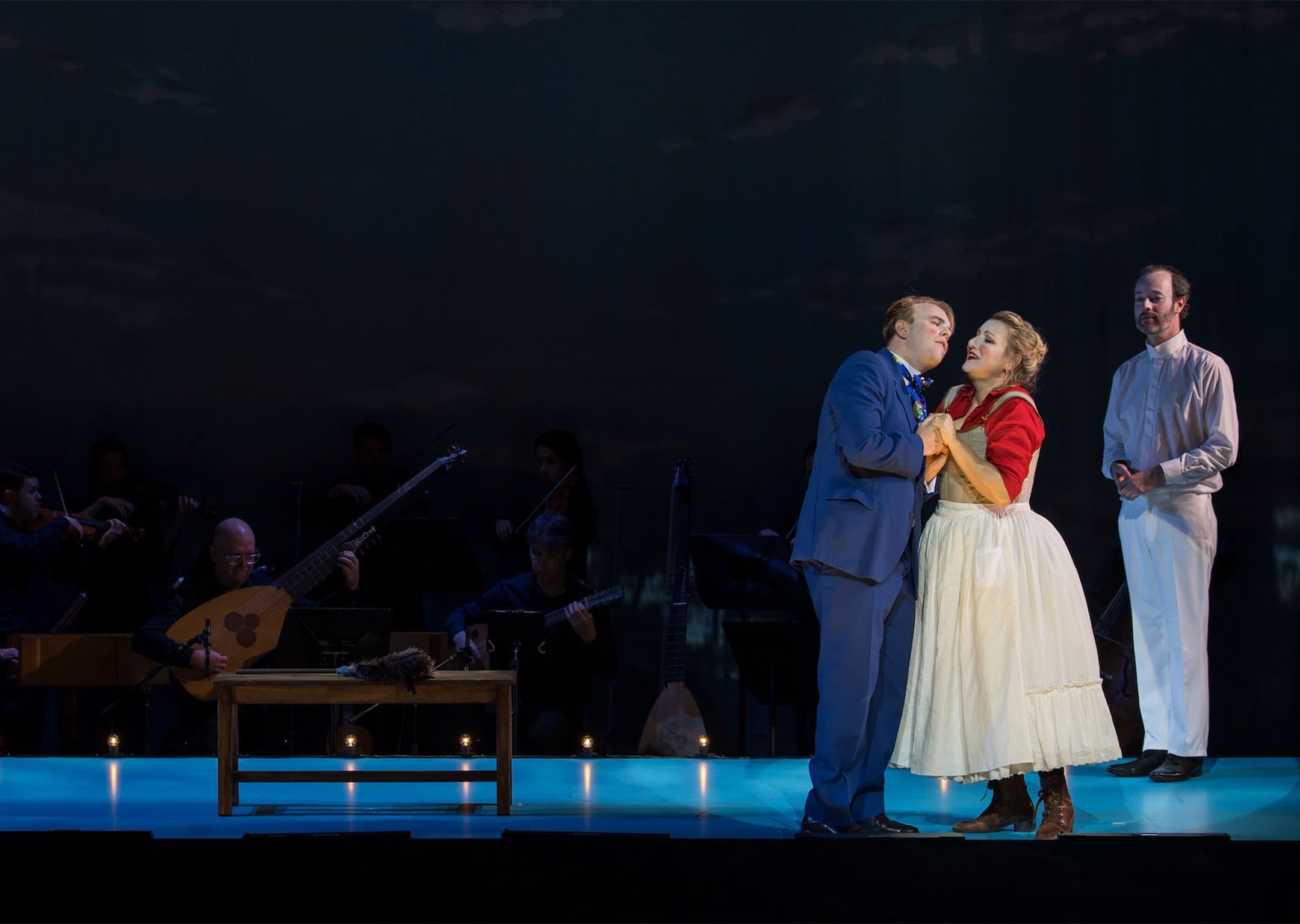Maid Made boss stage photos. A man in a blue suit embraces a woman in a skirt