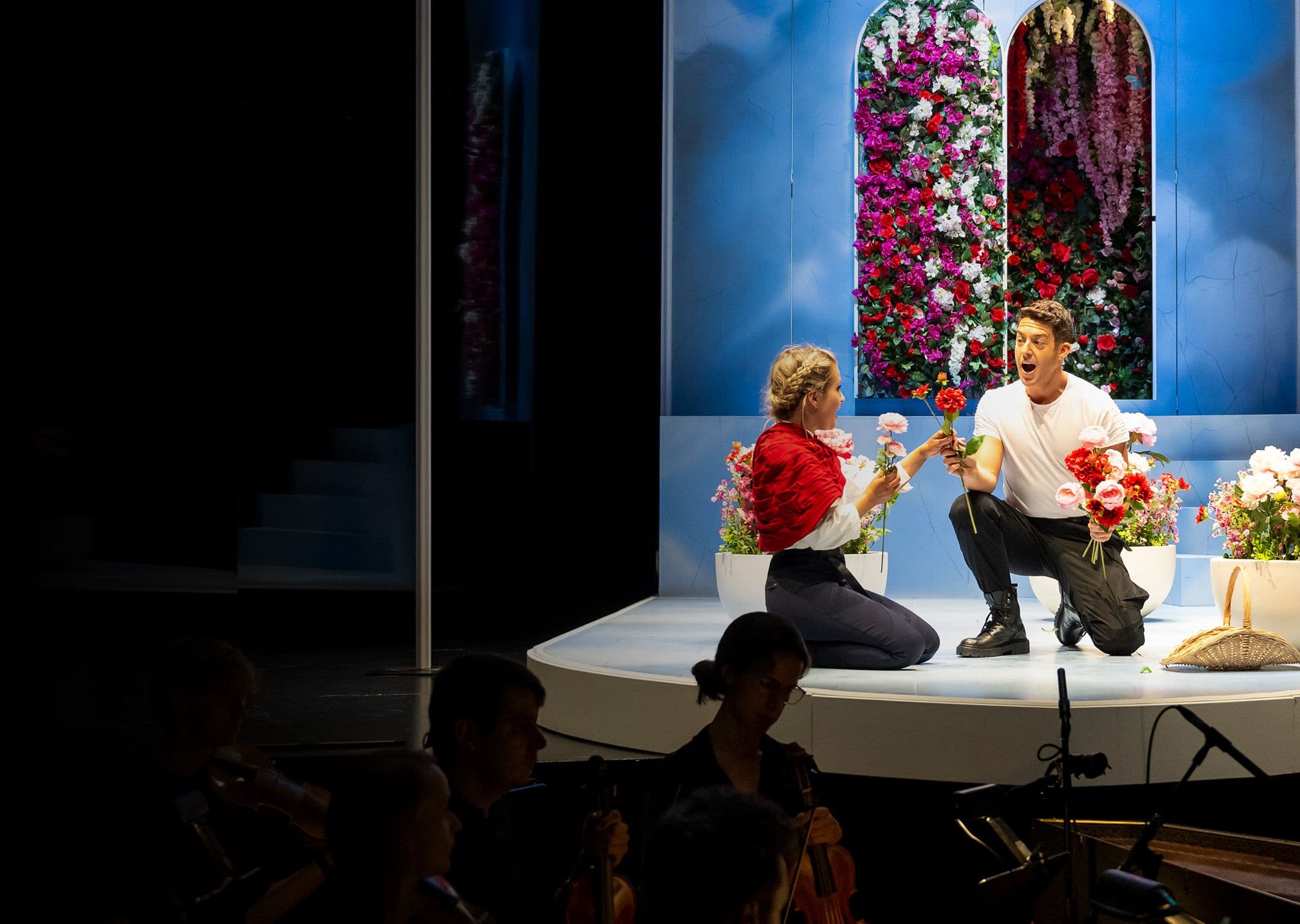 Tenor jake arditti as Rinaldo hands a flower to soprano Alexandro Oomens as Almiren