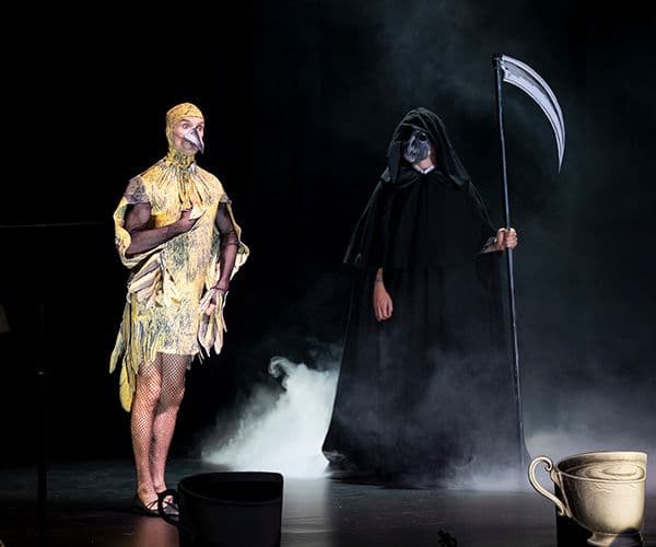 A man dressed as a canary standing next to the Grim Reaper