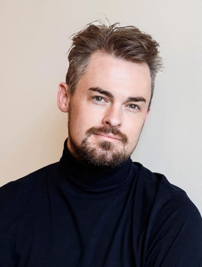 American-born tenor Kyle Stegall wears a black skivvy and has a short beard and short dark hair